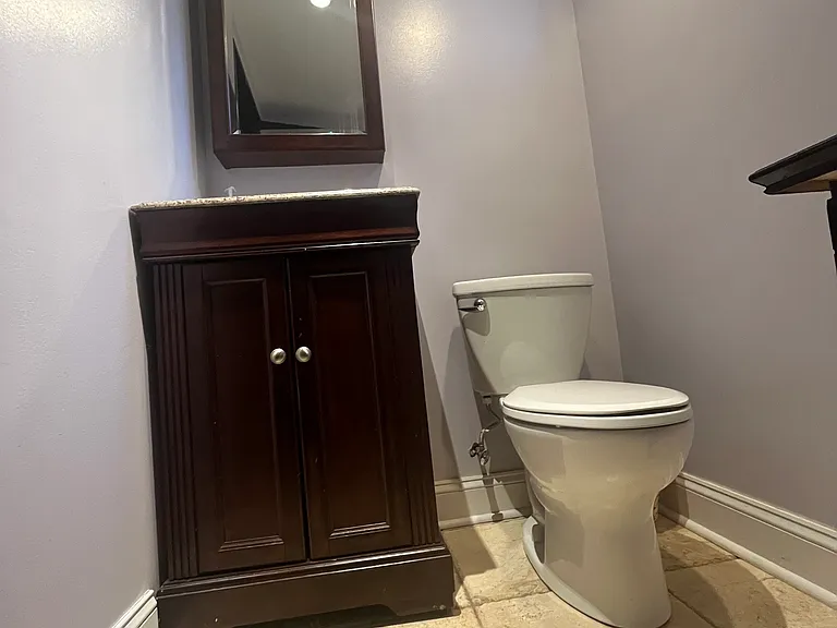 This is the half-bath in the apartment. Granite countertop and french-cut travertine flooring