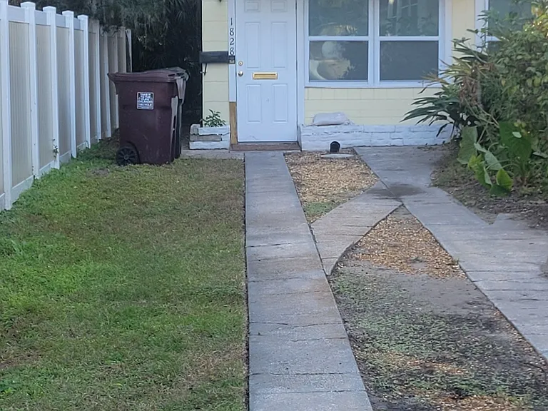 The entrance to the apartment is at the end of the driveway.