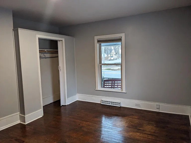 bedroom by bathroom with closet an refinished floor