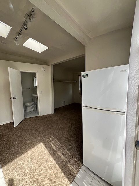 Entrance inside studio, full size refrigerator, looking towards bathroom
