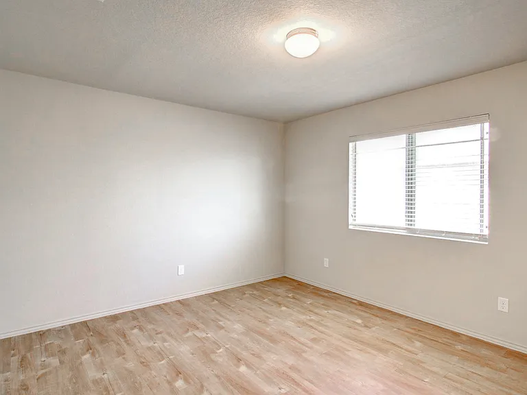 Bright, unfurnished room with natural light, neutral walls, and elegant wood flooring. Bright, unfurnished room with natural light, neutral walls, and elegant wood flooring.
