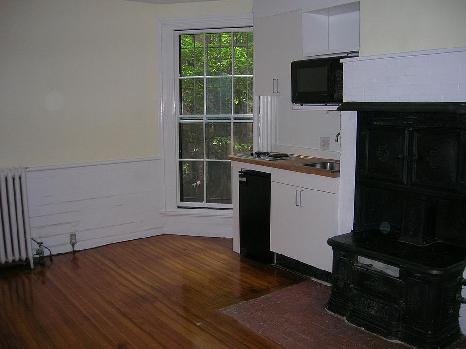 The yellow wall with white wainscoting is the back end of apartment. Window looks out onto the back yards of Lime St.