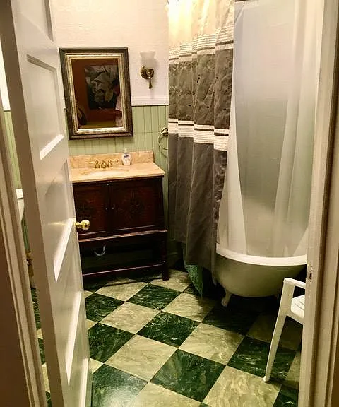 Bathroom with antique claw tub, French marble, and old English (vitrola?) cabinet