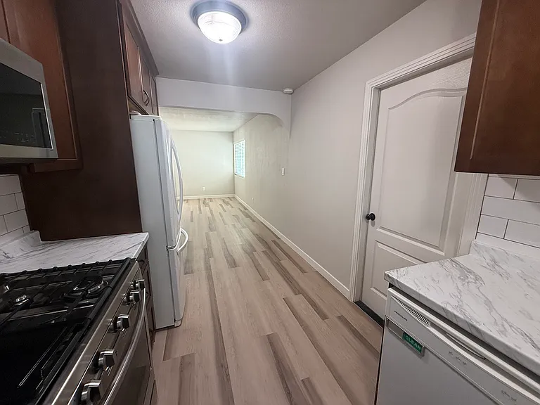 Kitchen view towards living room and garage access door.