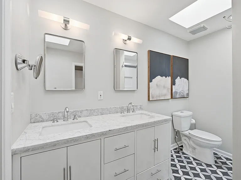 Updated primary bath with double vanity and walk-in shower