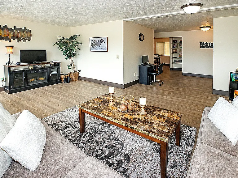 Inviting living room with elegant furnishings and open space, featuring a cozy seating area and a stylish home office nook.