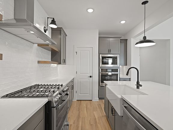 Kitchen with white apron-front sink floating shelves