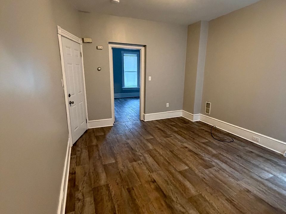 Living room with front door on the right. New flooring and paint.