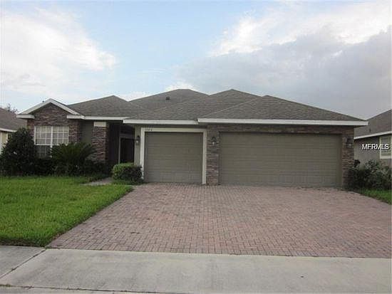 A large driveway leads to the three-car garage and covered front entryway