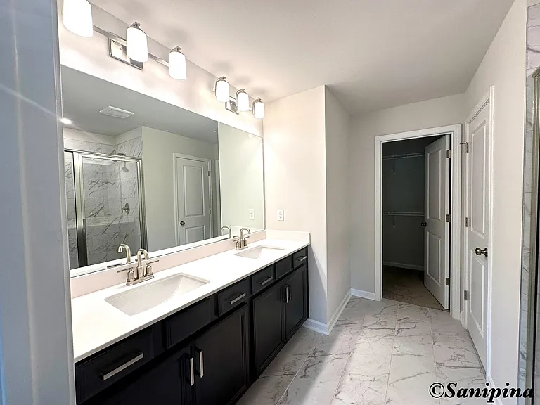 Master Bath
En Suite bath featuring Timberlake_ cabinets, cultured marble countertops, oval undermount sinks and Moen_ Gibson chrome faucet
Primary bath tile floor
Primary shower with fiberglass pan with glass shower door
Walk-in closet.