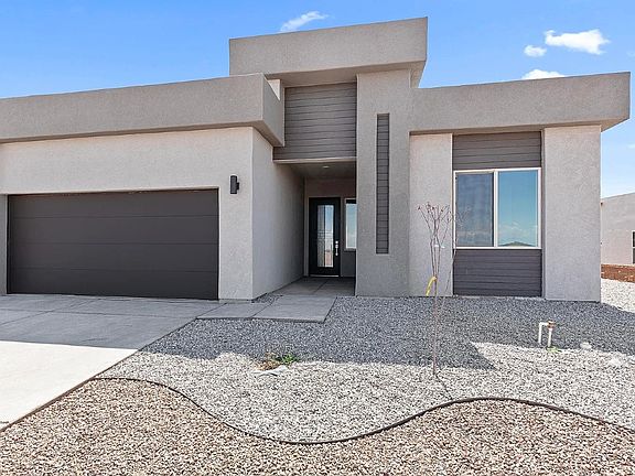 Modern single-story house with flat roof, gray stucco exterior, large front window, and double garag