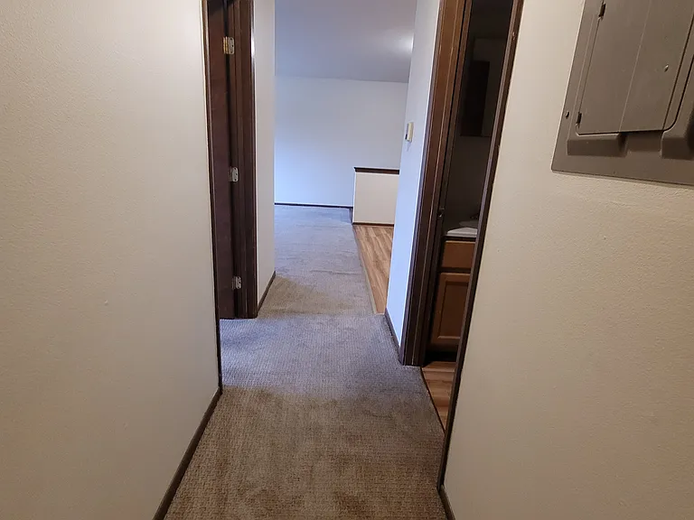 Hallway leading to full bathroom and bedrooms
