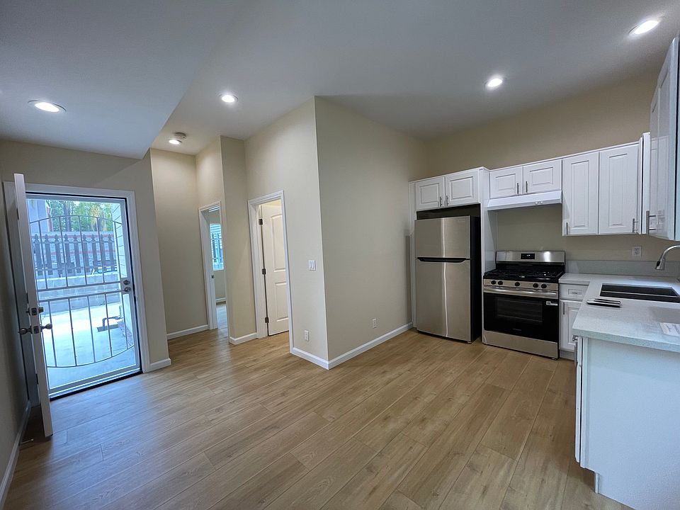 Open layout with high ceilings: kitchen, dining, and living area