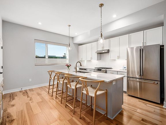 plenty of counter space, Cambria quartz countertops, GE cafe appliances (six-burner gas range, convection microwave, and large refrigerator).