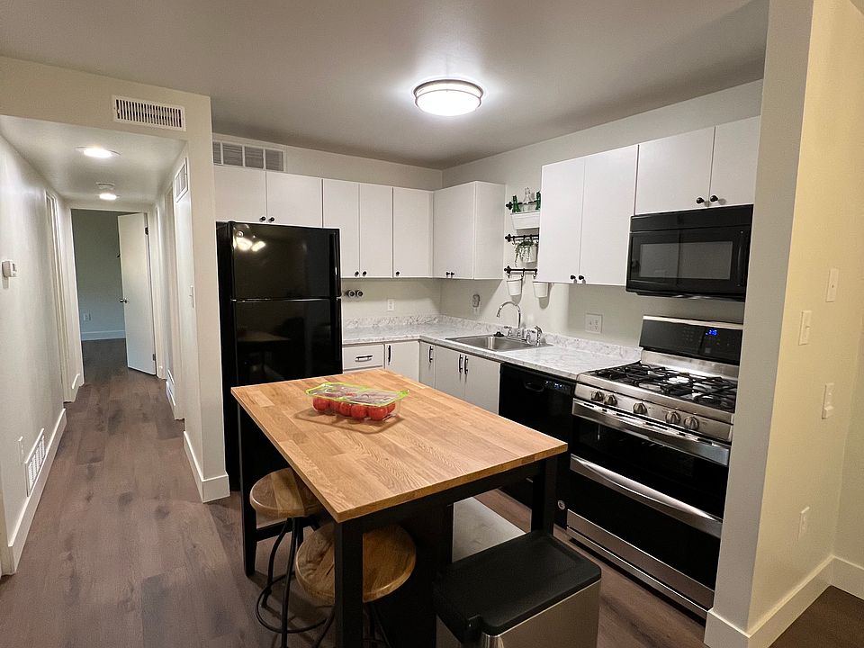 Updated kitchen featuring new countertops, refinished cabinets, a double-range oven, dishwasher, and garbage disposal. Large kitchen island with ample storage and a butcher block workspace perfect for culinary enthusiasts.