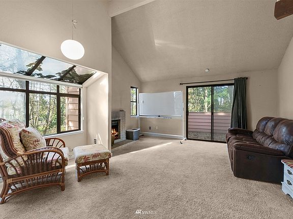 Large, light filled Living Room has wood burning fireplace and sliding glass door to the outside deck.  Storage closet is located on the deck - very convenient location!