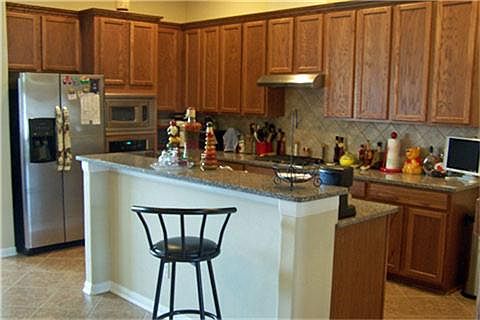 Open kitchen with island sink and granite counters.