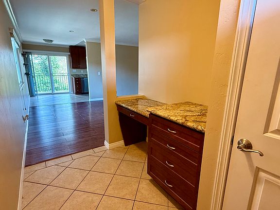Entryway, with a closet storage area (white door in photo), and a granite countertop work area with wood drawers.