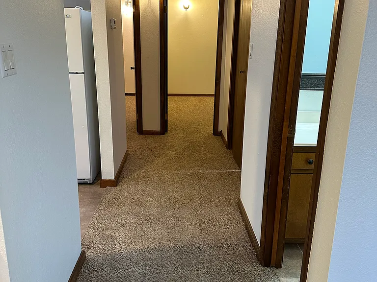 Hallway- bathroom on right, kitchen to the left, both bedrooms at the end of hallway