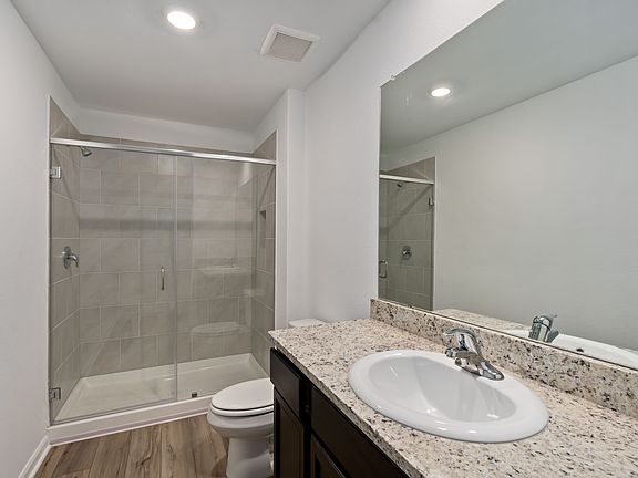 Master bathroom with a walk-in shower and granite countertops.