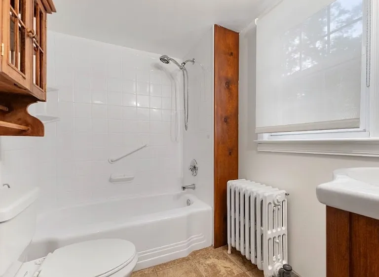Full bathroom setup featuring a classic tub and shower combo.