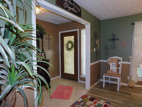 Entry with terrazzo tile. Leading to the dining room with recent wood look tile.