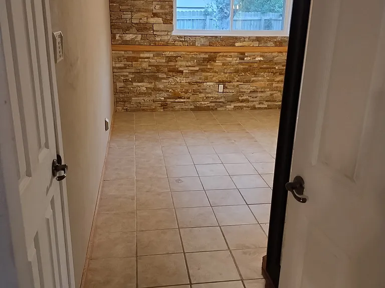 Looking into Master from Den. Master walk in closet on left. Stone wall seen in picture.