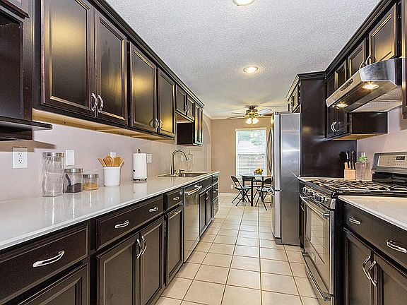 Updated contemporary Kitchen has been renovated with durable yet beautiful quartz counters, dark cabinets with upgraded soft-close feature and stainless steel appliances.