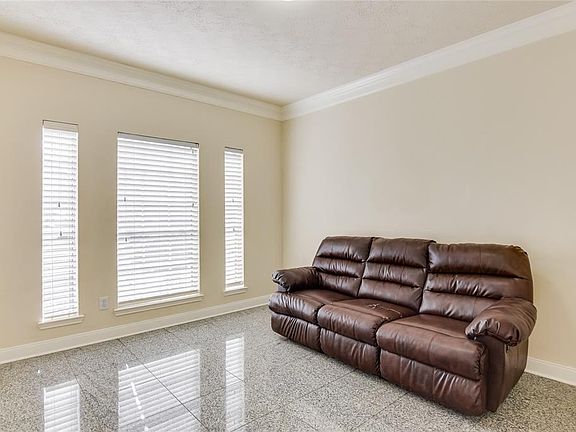 Study has crown molding and a wall of windows.