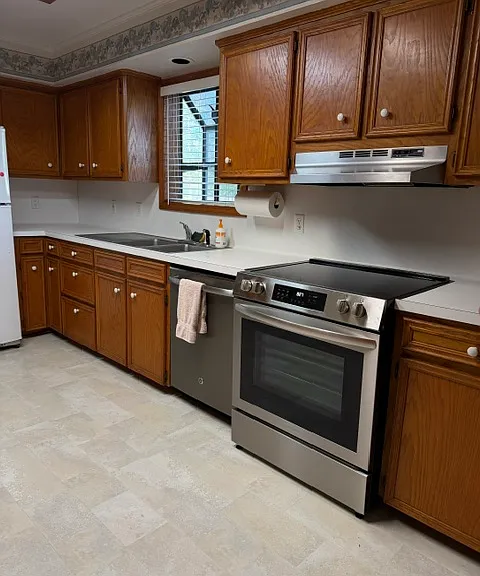west wall includes sunny, garden window for plants, deep, stainless double sink with drying rack, and new Frigidaire range with vent hood
