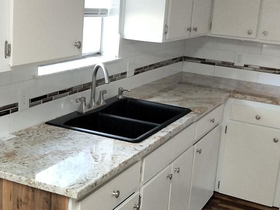 The granite countertops and backsplash really make this kitchen look beautiful.