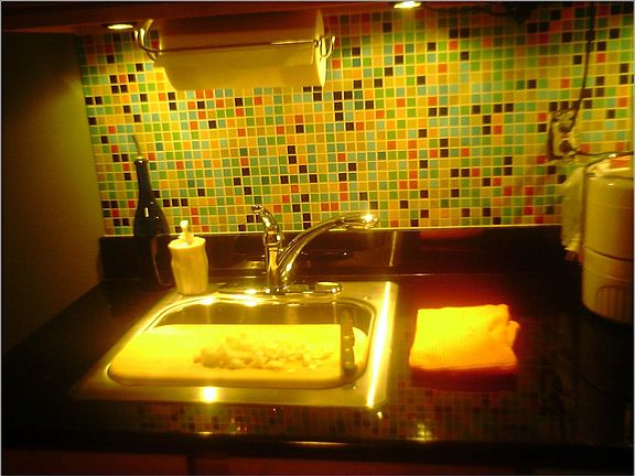 Completed granite and tile install with undercounter lighting
