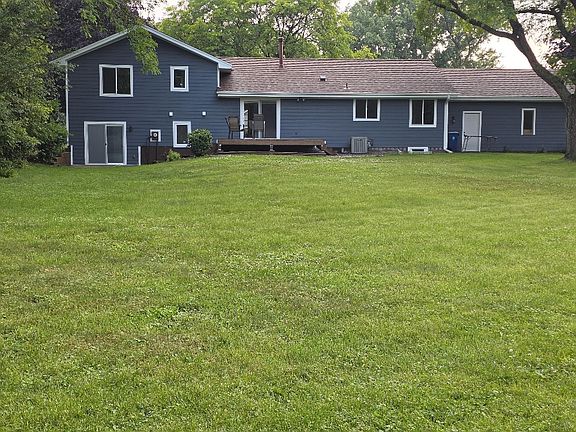 Back of home with walk out patio, wood deck and 2/3 acre.