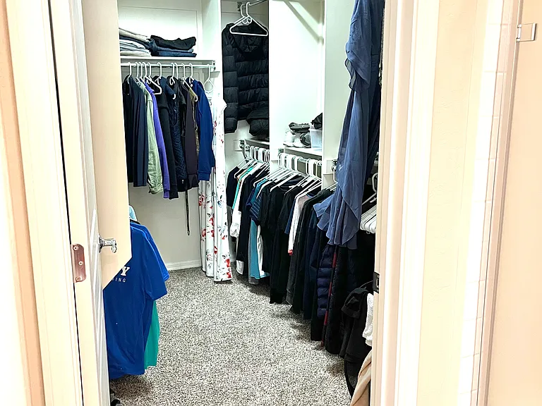 Walk-in closet off of en-suite bathroom in primary suite.