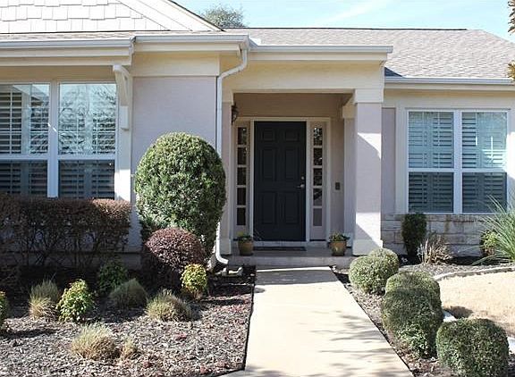 Guests are welcomed to the beautiful entrance of the home  via  a painted sidewalk and front porch.