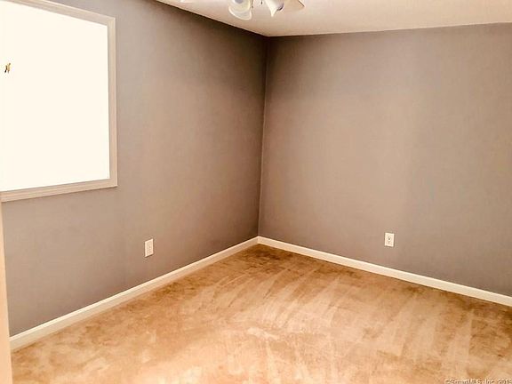 Master bedroom with free TV and walk in closet painted white