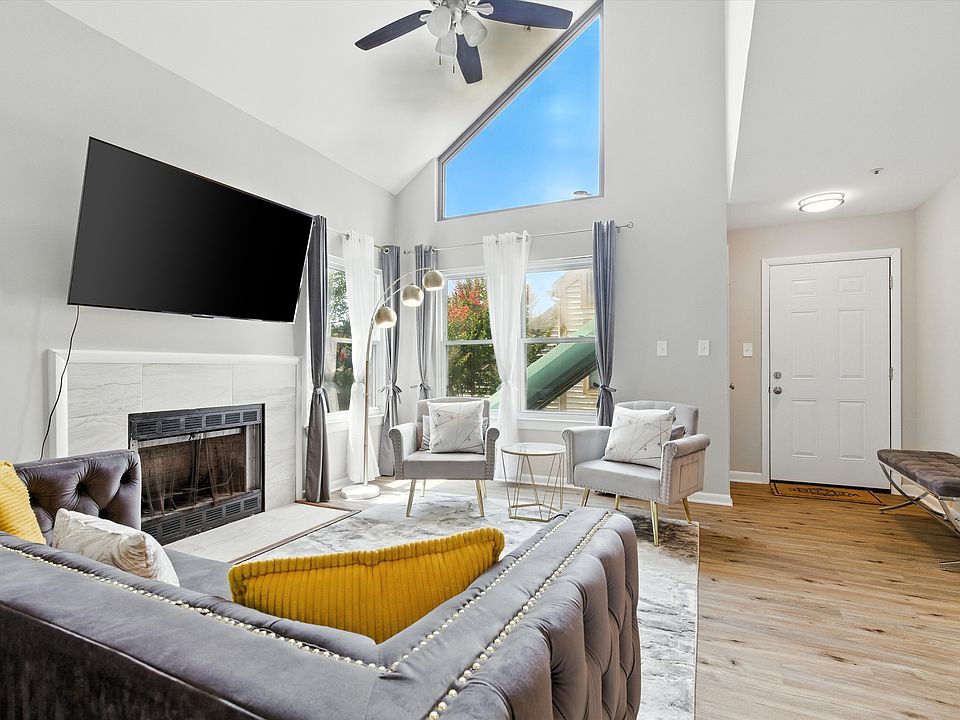Living room: High ceiling with lots of natural light and wood-burning fireplace.