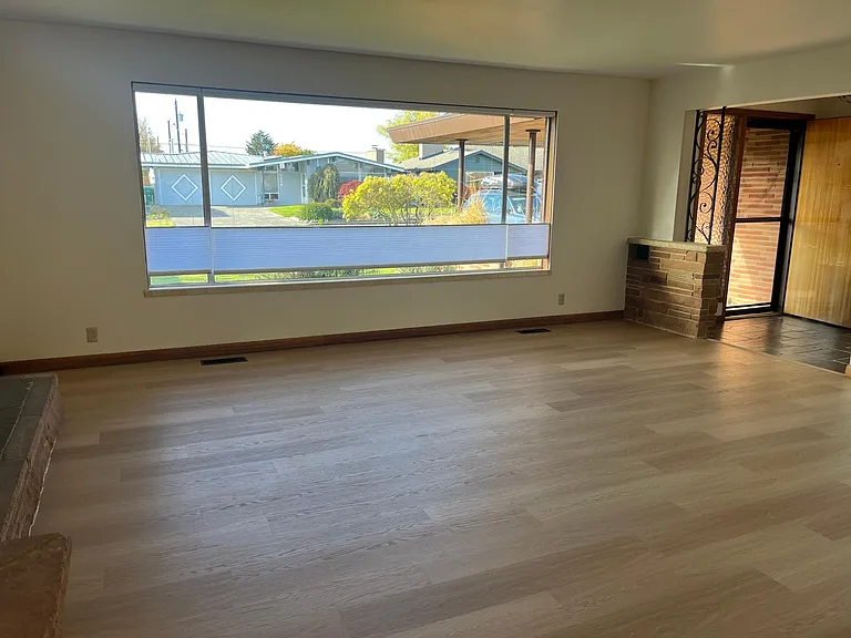 Large, comfortable living room with lots of natural light. It looks out on the front yard and a quiet neighborhood street.