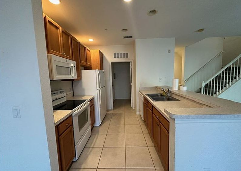 Modern kitchen with all working appliances and adjacent room with washer and dryer.