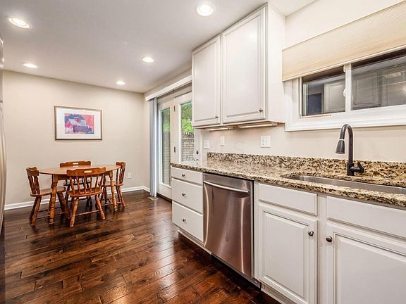 Light-filled eat-in kitchen with direct door access to private patio and semi-enclosed carport