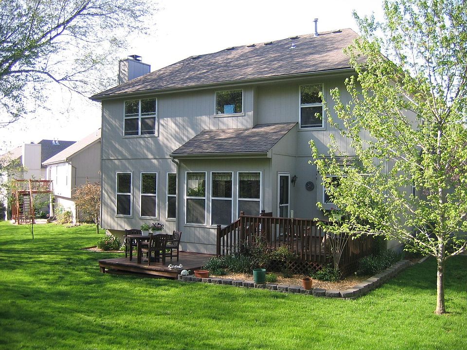 Back of home with deck and beautiful landscaping