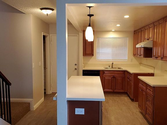 New kitchen with quartz counter tops, tile floor, cabinets and dishwasher.
