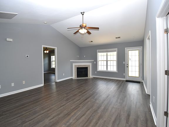 Wow what a great living room. Vaulted Ceiling with fan and gas log fireplace.