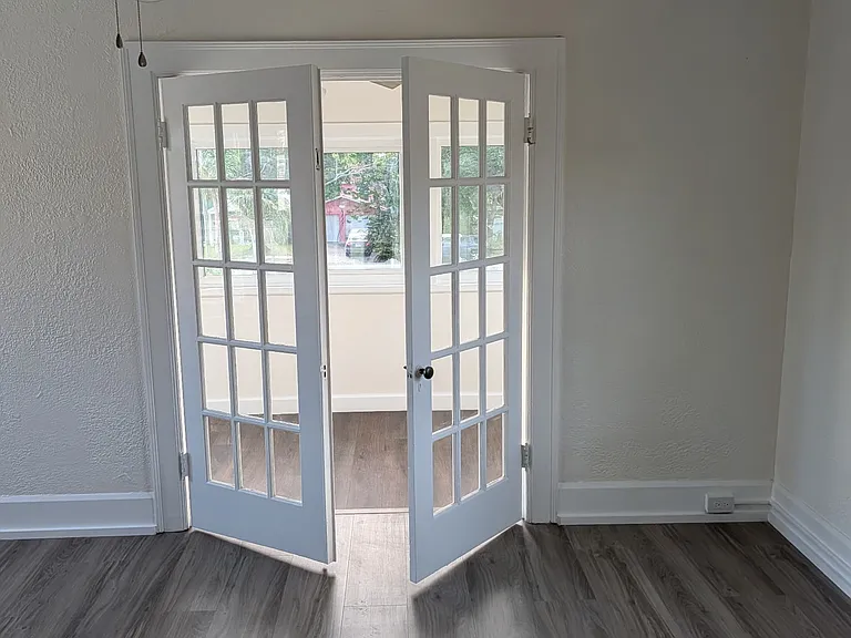 French doors at end of living room open to lovely porch.