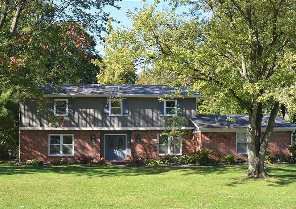 Classic Two Story with warm red brick is situated on a 1/2 acre lot with mature trees!