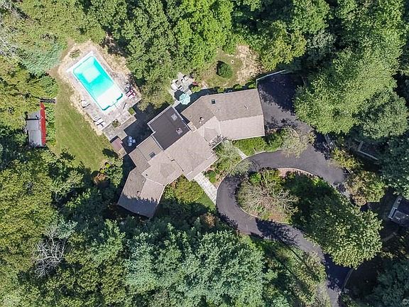 With circular drive, pool, cottage, cabana, stone walls and mature plantings, this property is a true retreat.