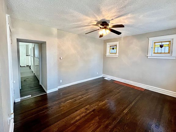 Spacious family room featuring new ceiling fan, stained glass windows, newly redone floors, fresh paint and lots of natural sunlight