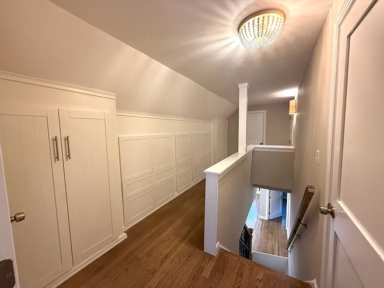 Custom built-in storage on upstairs landing includes two closets and additional shelving