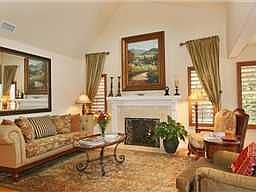 Living room with vaulted ceilings, fireplace, and hardwood floors.