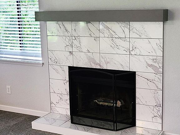 Gorgeous tile surround. Nice mantle and hearth.